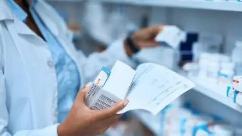 Imagen de un farmacéutico cogiendo medicamentos Imagen de un farmacéutico cogiendo medicamentos