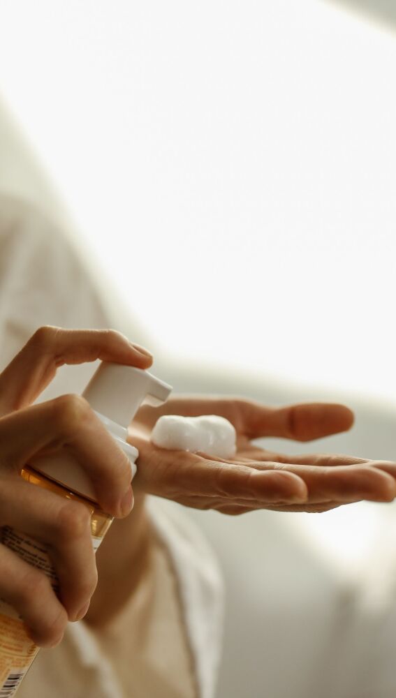 Mujer poniéndose una espuma cosmética en la mano
