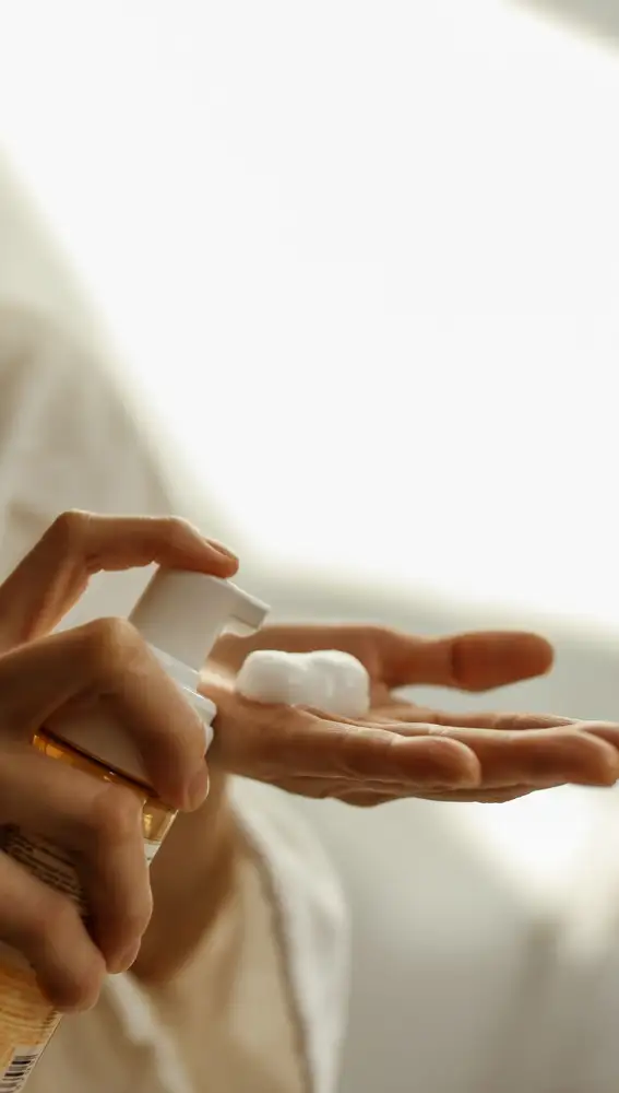 Mujer poniéndose una espuma cosmética en la mano Mujer poniéndose una espuma cosmética en la mano