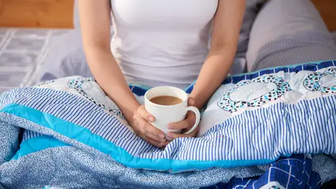 Mujer con una manta y un té Mujer con una manta y un té