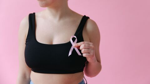 Mujer sosteniendo una cinta rosa que simboliza la concienciación sobre el cáncer de mama