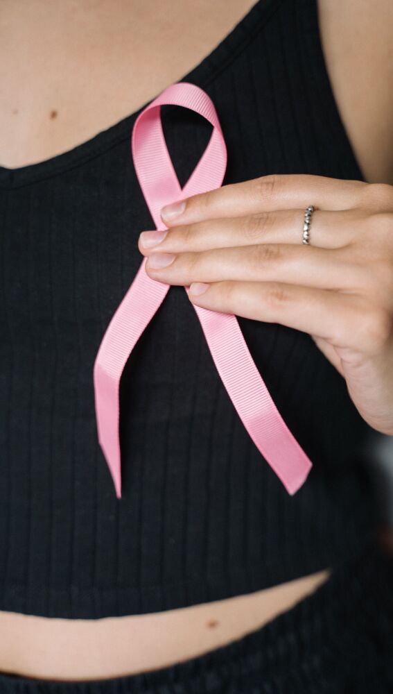Mujer sosteniendo una cinta rosa que simboliza la concienciación sobre el cáncer de mama