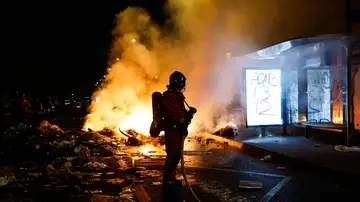 Un bombero frente a una barrica en llamas en París Un bombero frente a una barrica en llamas en París